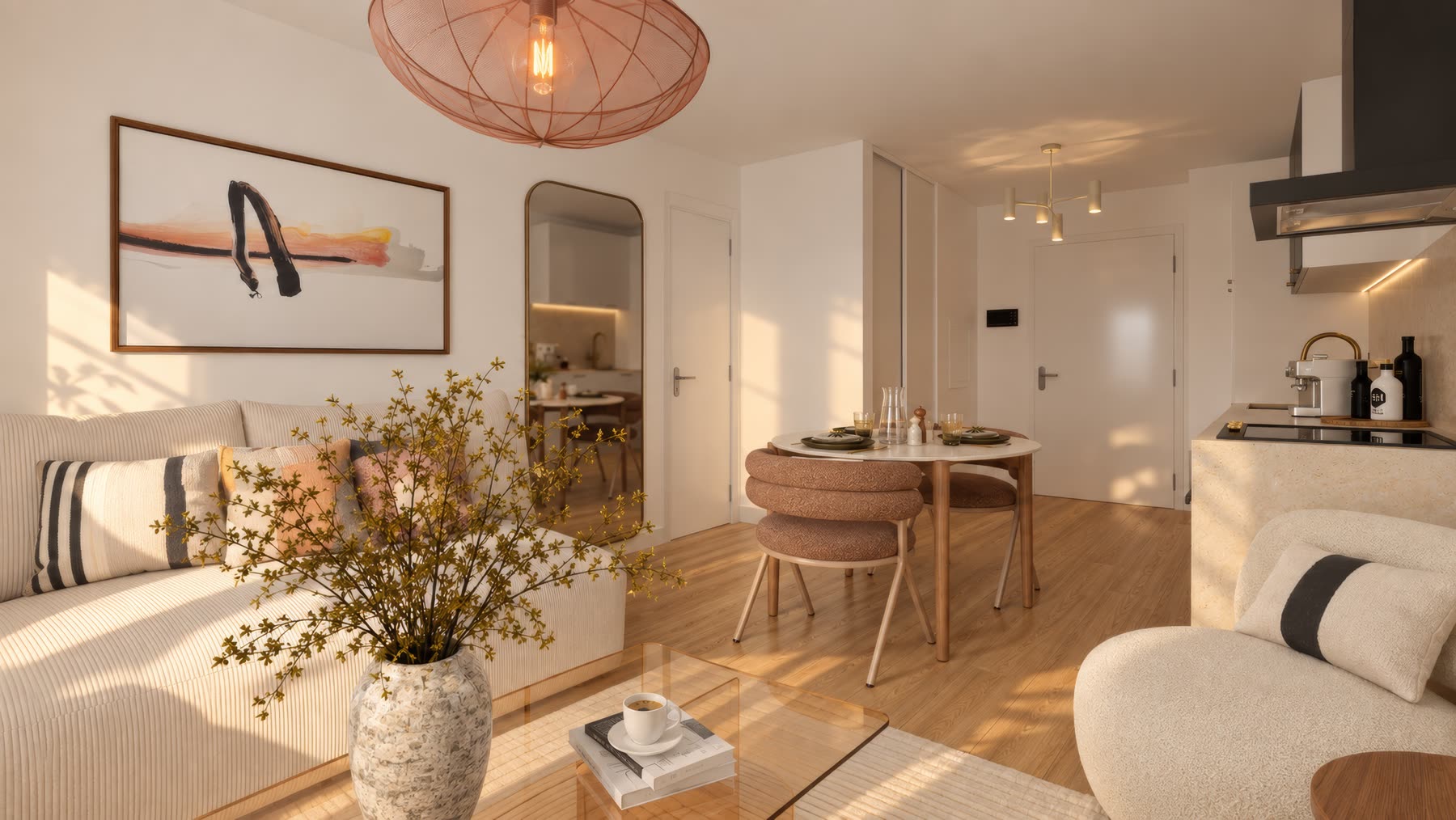 Séjour du T2 : canapé côtelé, suspension rose, table ronde et cuisine en arrière-plan