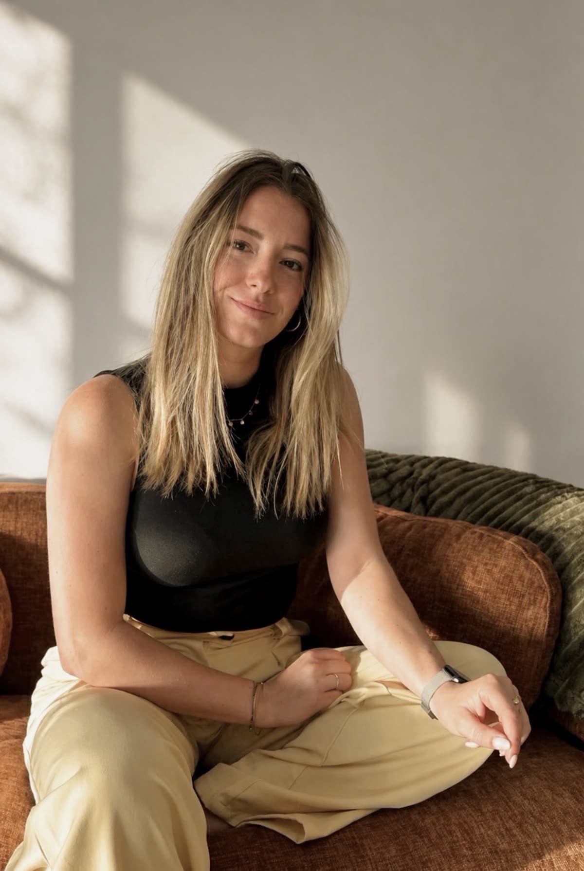 Lori Meresse, fondatrice de 3Dmesures, assise sur un canapé en velours rouille