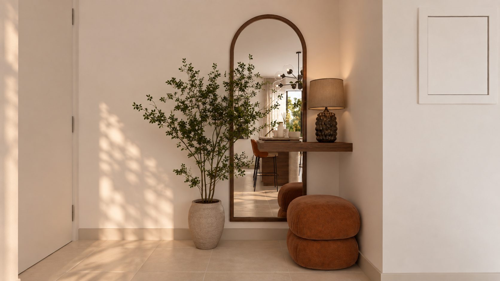 Entrée : miroir en arche, console murale en noyer, lampe et poufs cognac